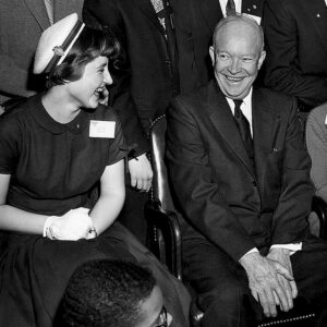1955 President Dwight Eisenhower visits with STS 1955 finalists Carol MacKay (left) and Roberta Colman (right). For her research project, MacKay developed her own vaccine to test whether mice could be successfully vaccinated against a strain of influenza