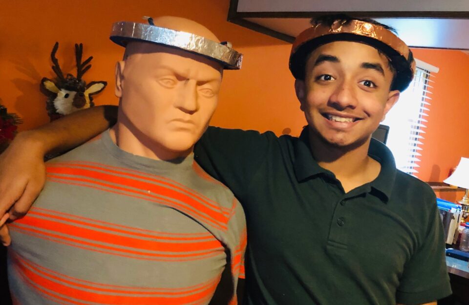 Ravindu poses with Bob, his test dummy, as they both wear the impact Absorbing and Alerting (iAAA) headband, Ravindu's invention to alert people when someone has fallen and needs help.