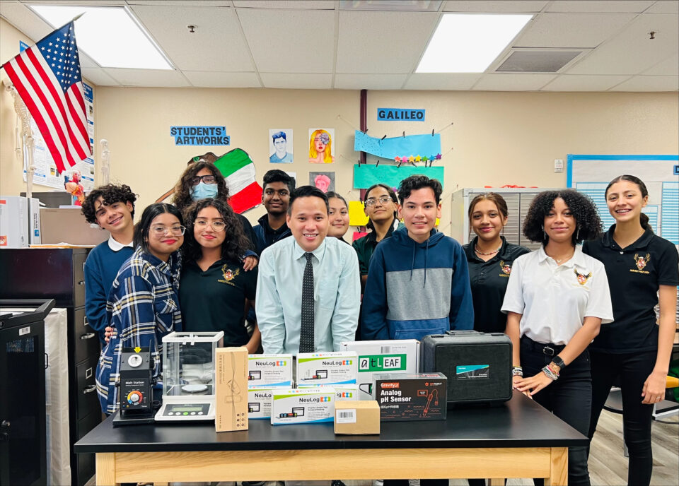 SRG recipient Alfred Santos and his students standing behind a table showing various boxes of lab equipment.